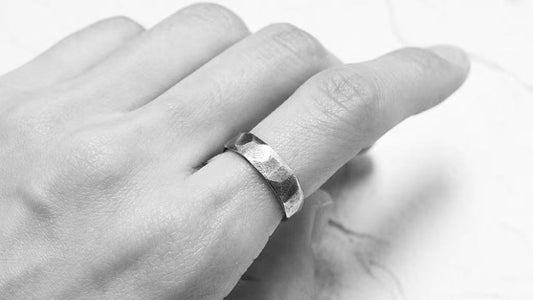 Close-up of a textured wedding ring shown on the hand